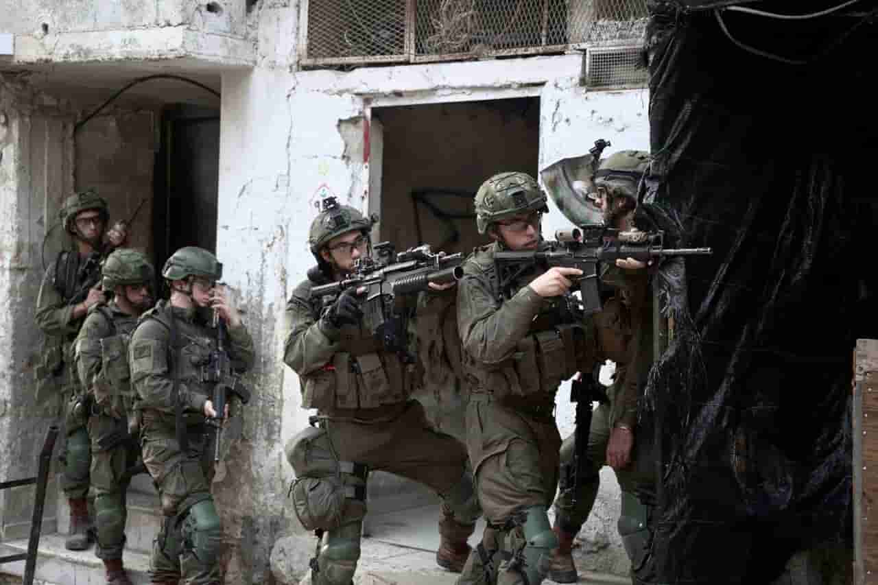 Israeli forces raid West Bank towns, helicopters fire near Gaza camp